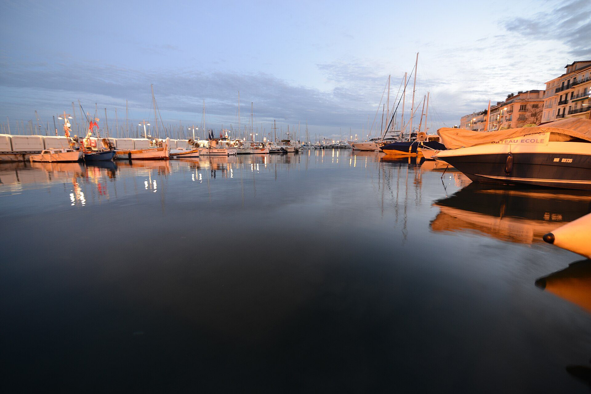 Vieux Port w Cannes z zacumowanymi jachtami i miastem w tle